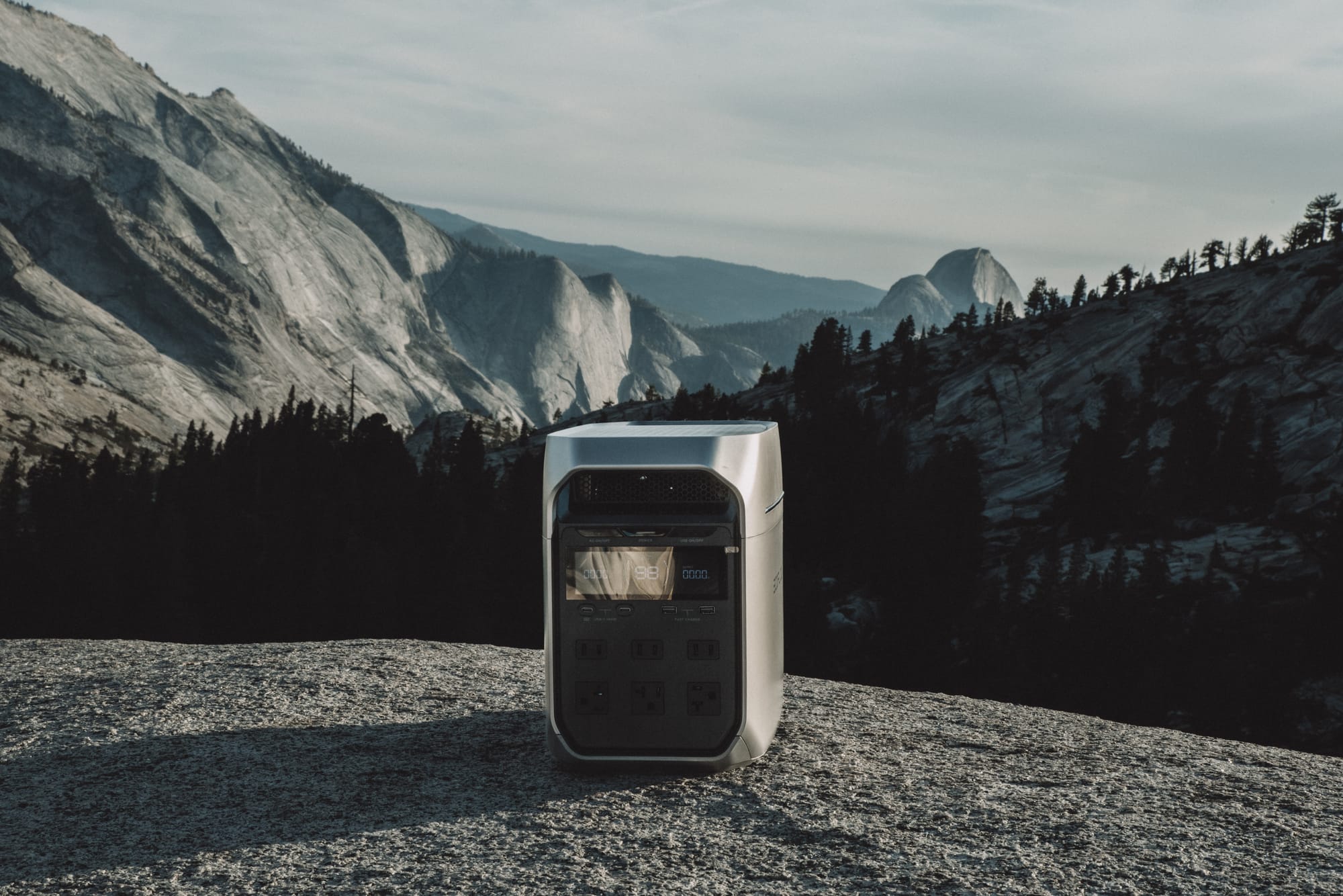 DELTA 3 Plus standing on a granite slab, front display lit, a forested valley and granite domes behind it