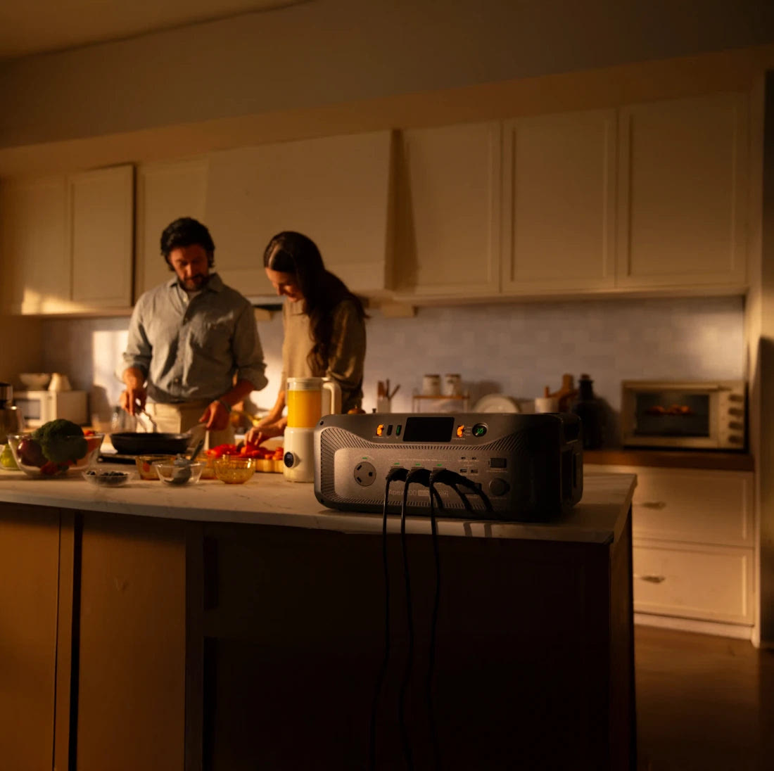 BLUETTI image of the Apex 200 on a kitchen counter powering appliances while two people cook by lamplight
